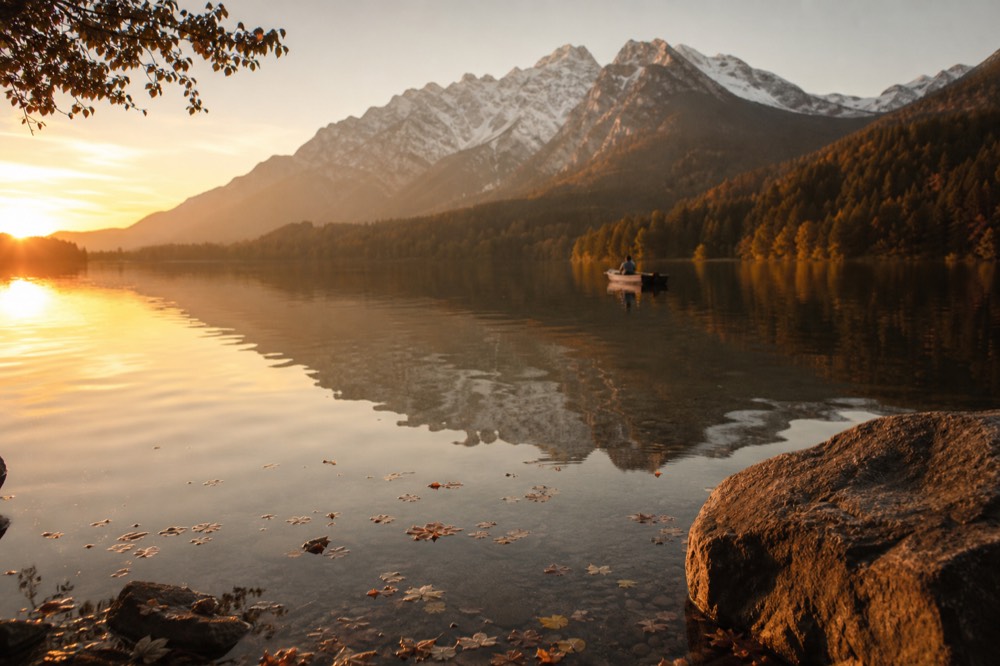 Alpine peaks reflected in a calm lake at golden hour, no text, no logos, no people