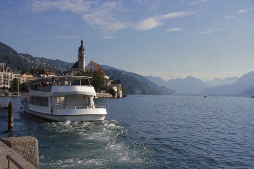 Historic paddle steamer moored at a Lake Lucerne pier with snow-capped mountains behind, no text, no logos, no people