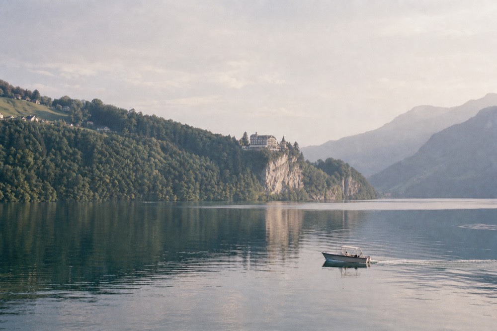 Catamaran and paddle steamer on Lake Lucerne seen from a forested shore, no text, no logos, no people