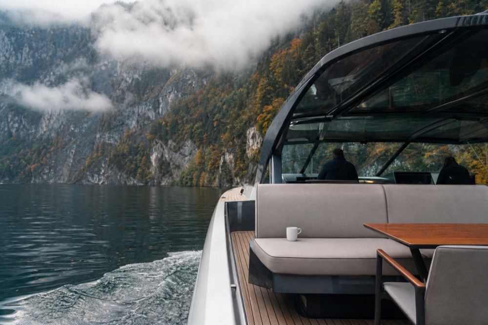 A panorama yacht cruising past forested cliffs on Lake Lucerne, no text, no logos, no people