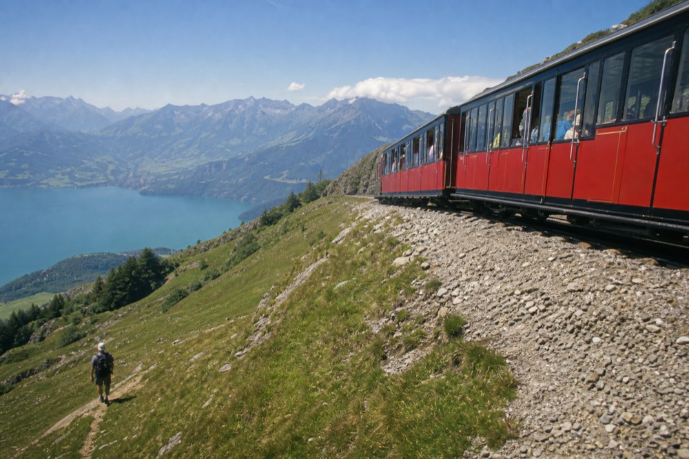 A cogwheel train climbing a green mountainside above Lake Lucerne, no text, no logos, no people