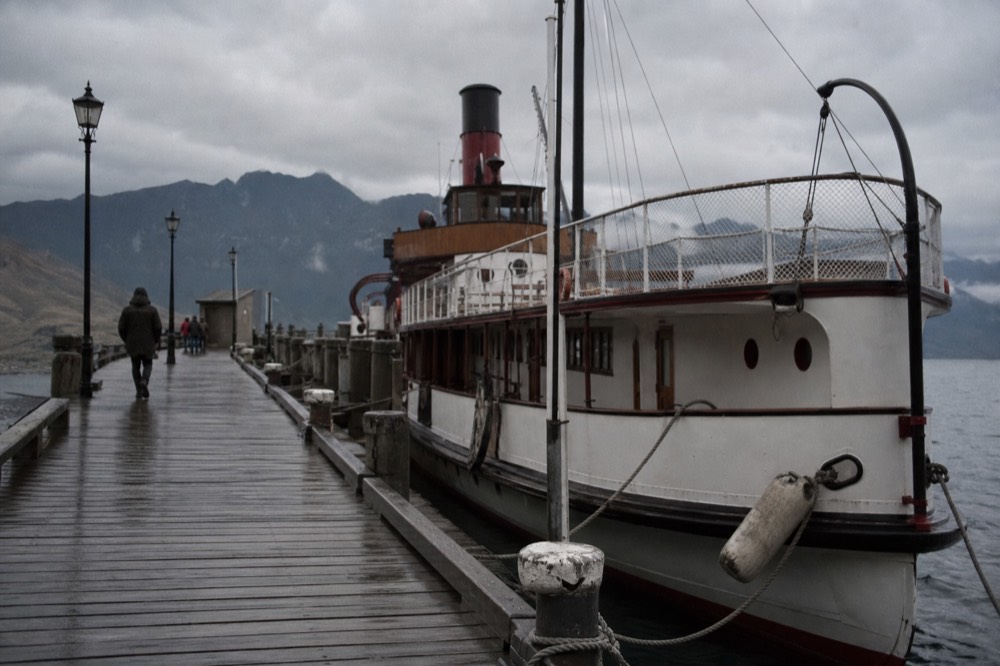 Nineteenth-century paddle steamer moored at a Lake Lucerne pier with mountains behind, no text, no logos, no people