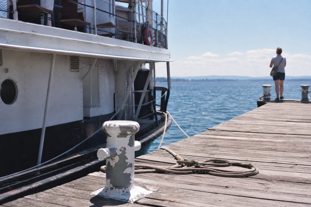A white lake steamer moored at a wooden pier on Lake Lucerne, no text, no logos, no people.