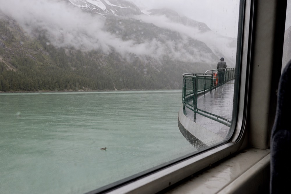 A passenger ferry crossing calm water toward forested mountains on Lake Lucerne, no text, no logos, no people.