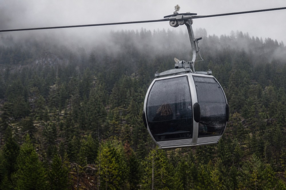 Aerial cable car suspended over dense pine forest on the Kriens side of Pilatus, no text, no logos, no people