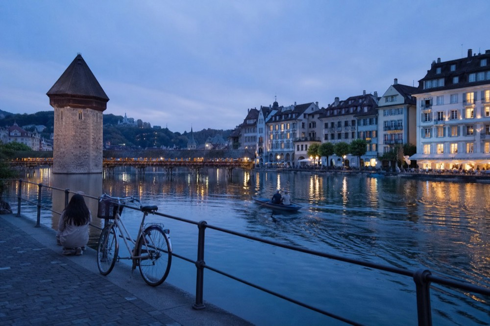Lucerne Chapel Bridge and old town reflected in the lake at dusk, no text, no logos, no people